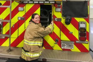 Woman firefighter next to a firetruck