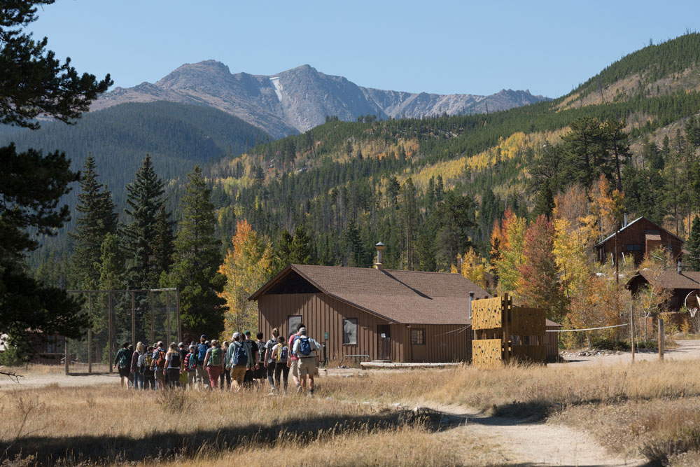 CSU students walking next to cabins in a mountain landscape
