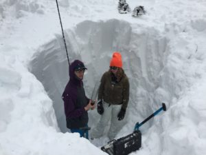 Students in a sustainability graduate program address stand in deep snow and calculate