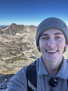 Jack in a selfie with mountains behind him