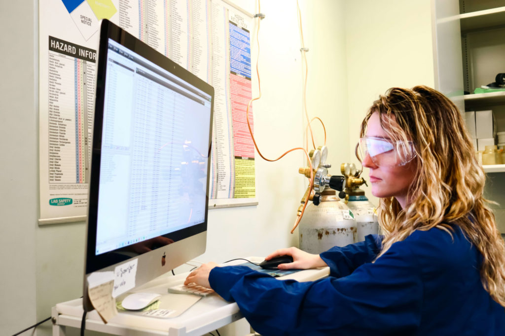 A graduate student analyzes lab results at a computer.