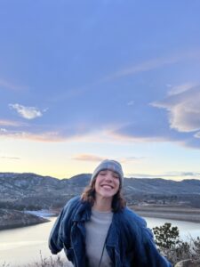 Jill smiling at the camera in front of Horsetooth Reservoir