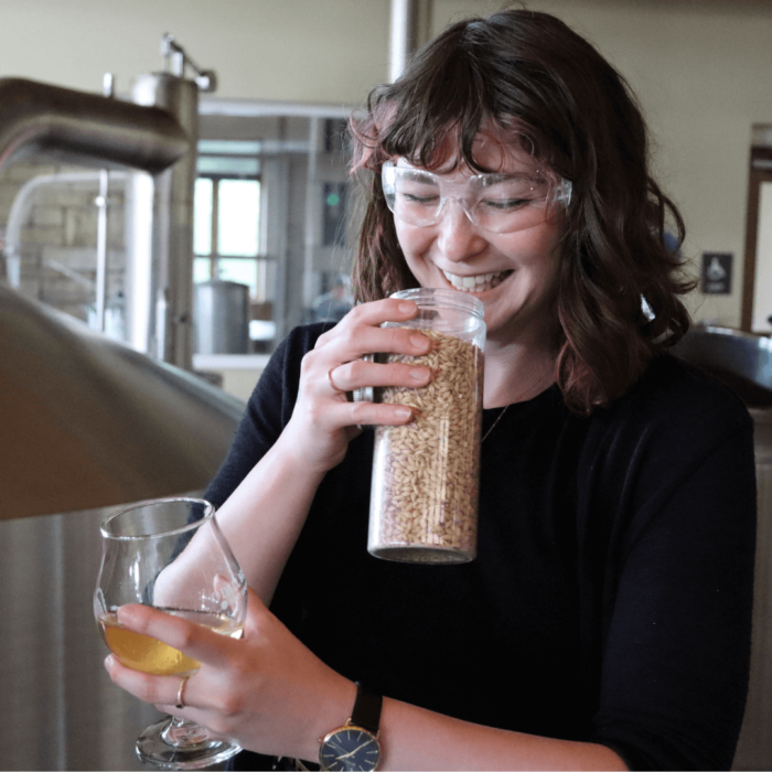 Student smells fresh barley during sustainable brewery tour